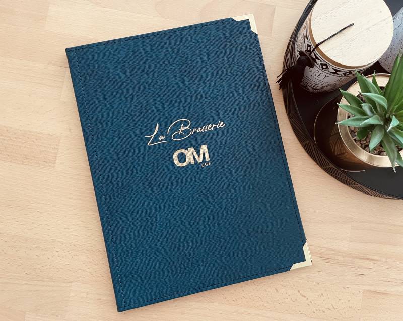 Porte menu rigide en simili cuir bleu foncé strié avec motif marquage doré pour restaurant OM à Marseille 13