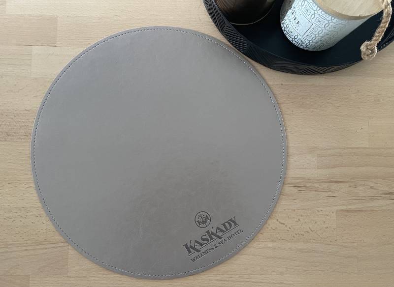 Set de table rond en simili cuir gris avec personnalisation à chaud et sûrpiqure pour hôtel restaurant à Bruges en Belgique